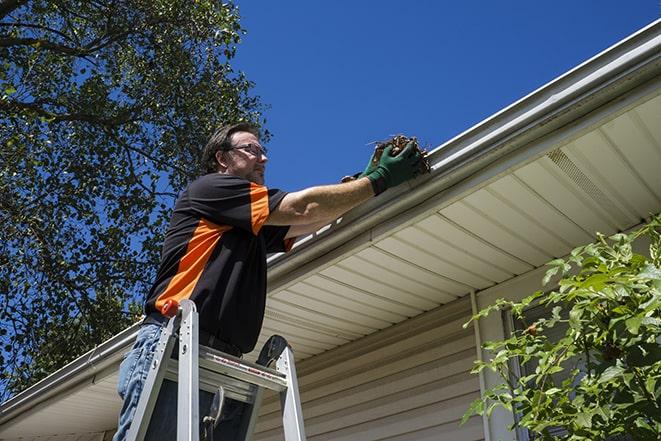 a professional repairing a leaking gutter to prevent water damage in Banning, CA